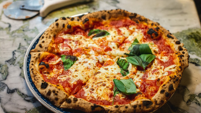 Pizza margherita en cuisson dans un four à bois à haute température
