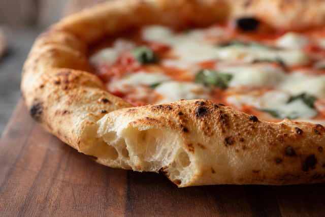 Corniche de pizza napolitaine gonflée et alvéolée avec taches de cuisson léopard