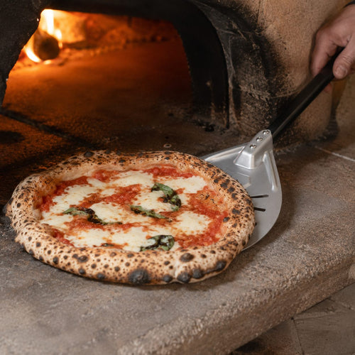Pelle à pizza tournante utilisée pour faire pivoter une pizza dans un four à bois