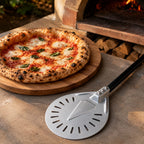 Pizza napolitaine dorée et pelle à pizza tournante près d'un four à bois