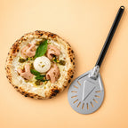 Pelle à pizza tournante Ø 23 cm posée à côté d'une pizza napolitaine, comparaison de taille