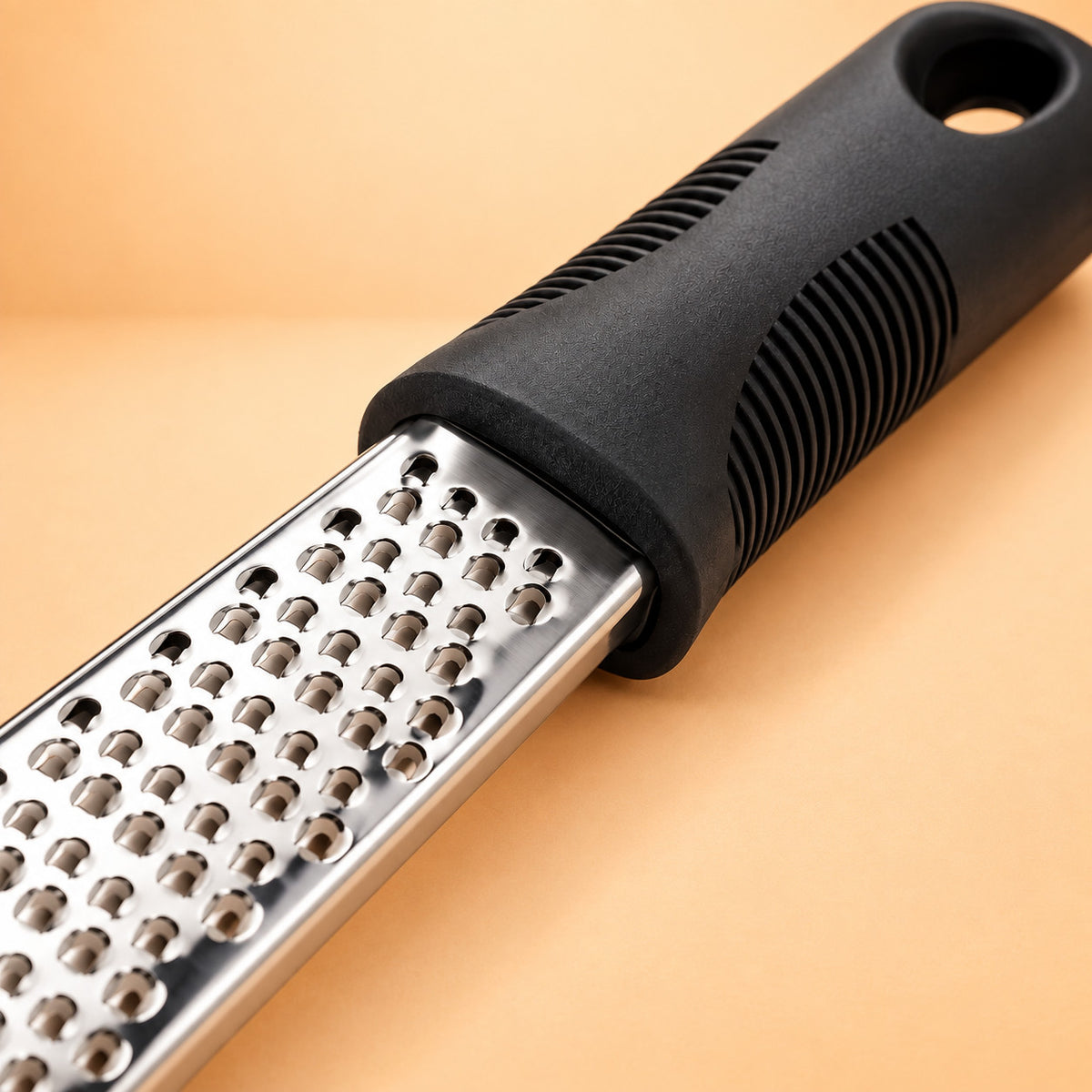 Lame en inox de la râpe à parmesan, vue rapprochée sur les trous